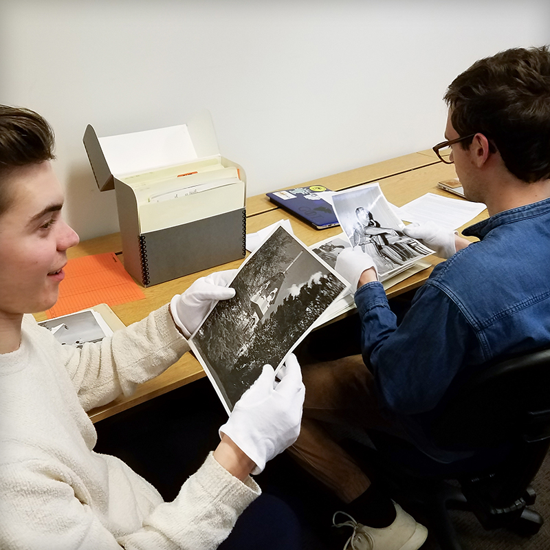 2 students examining old photos