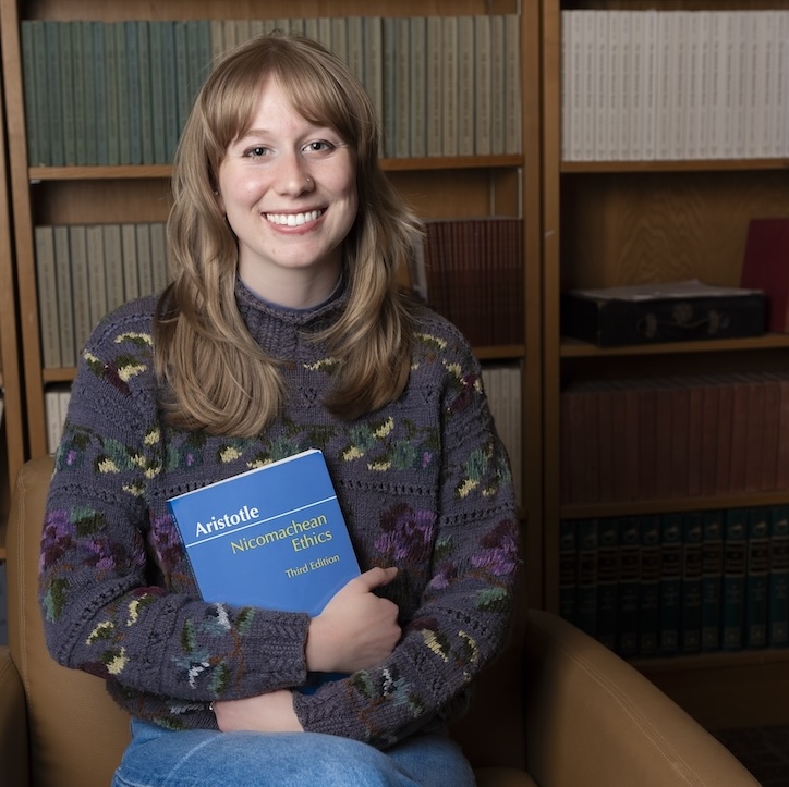 a woman sitting on a chair holding a book
