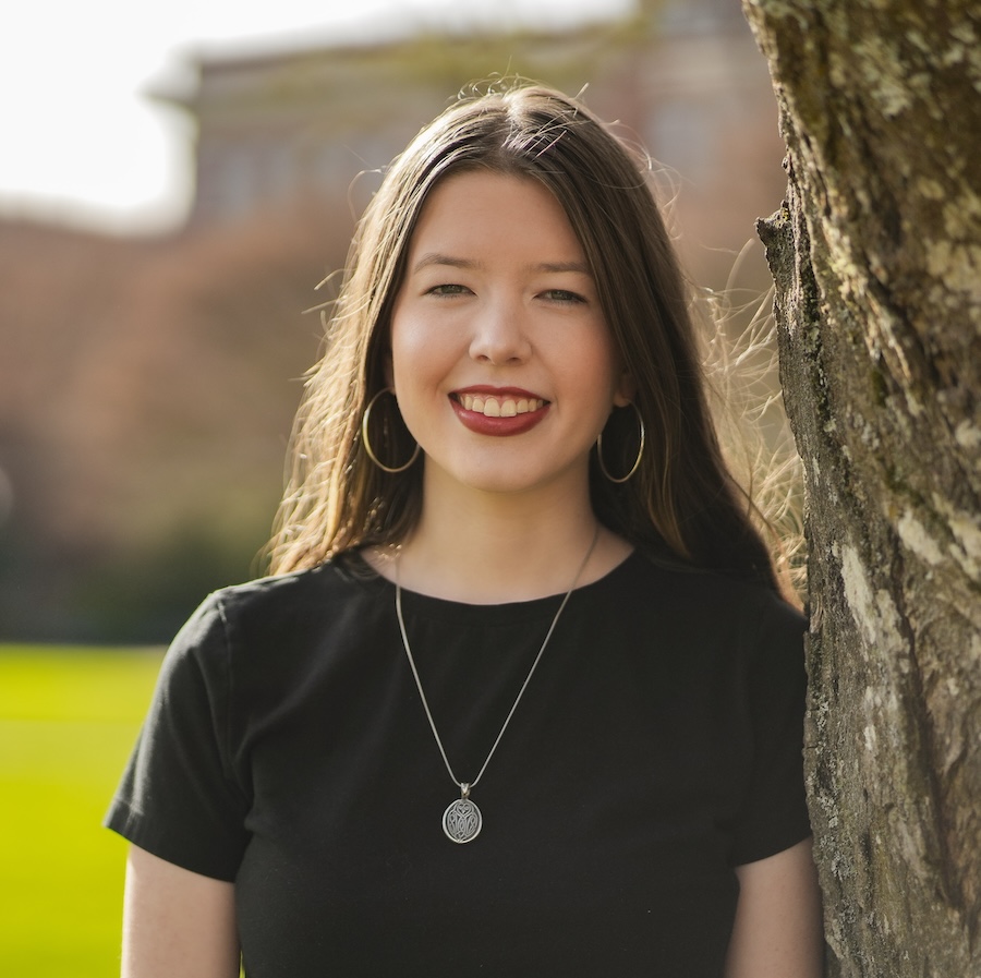 woman leaning up against a tree