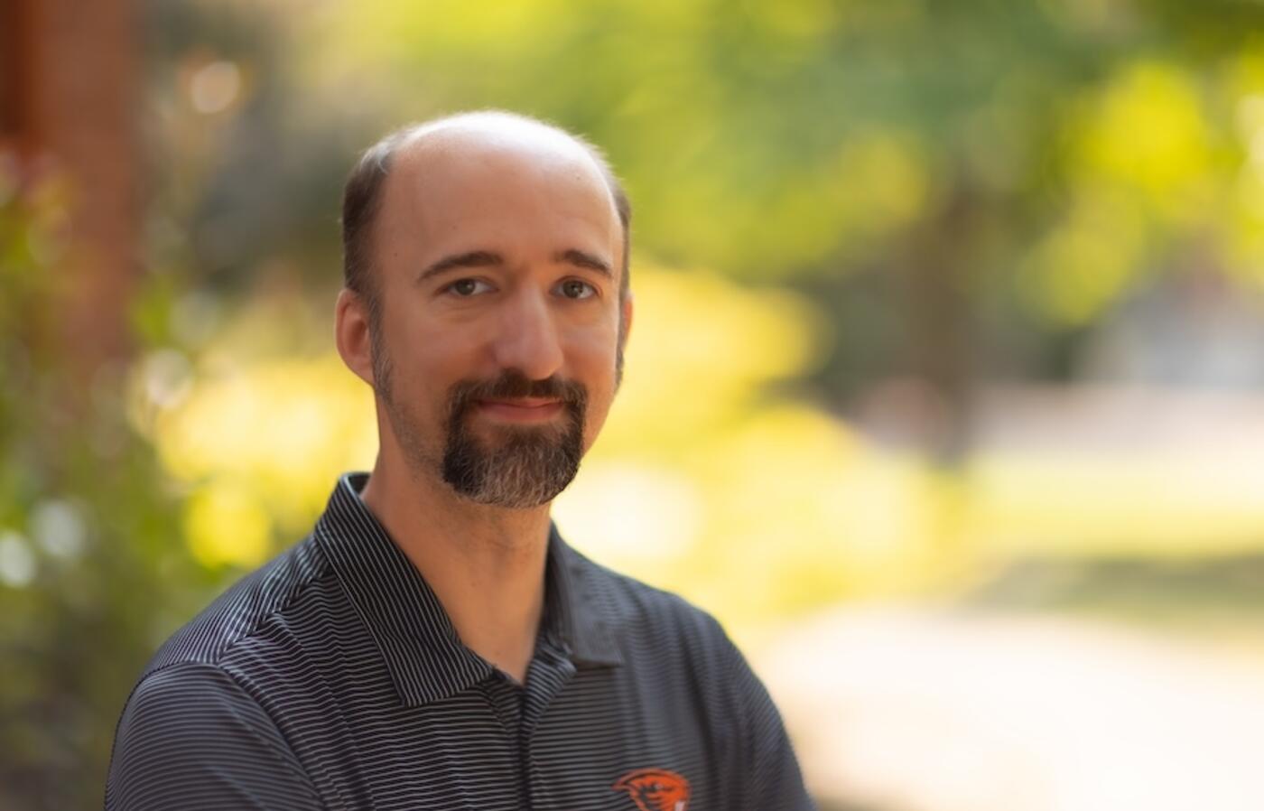 man in black shirt smiling at the camera