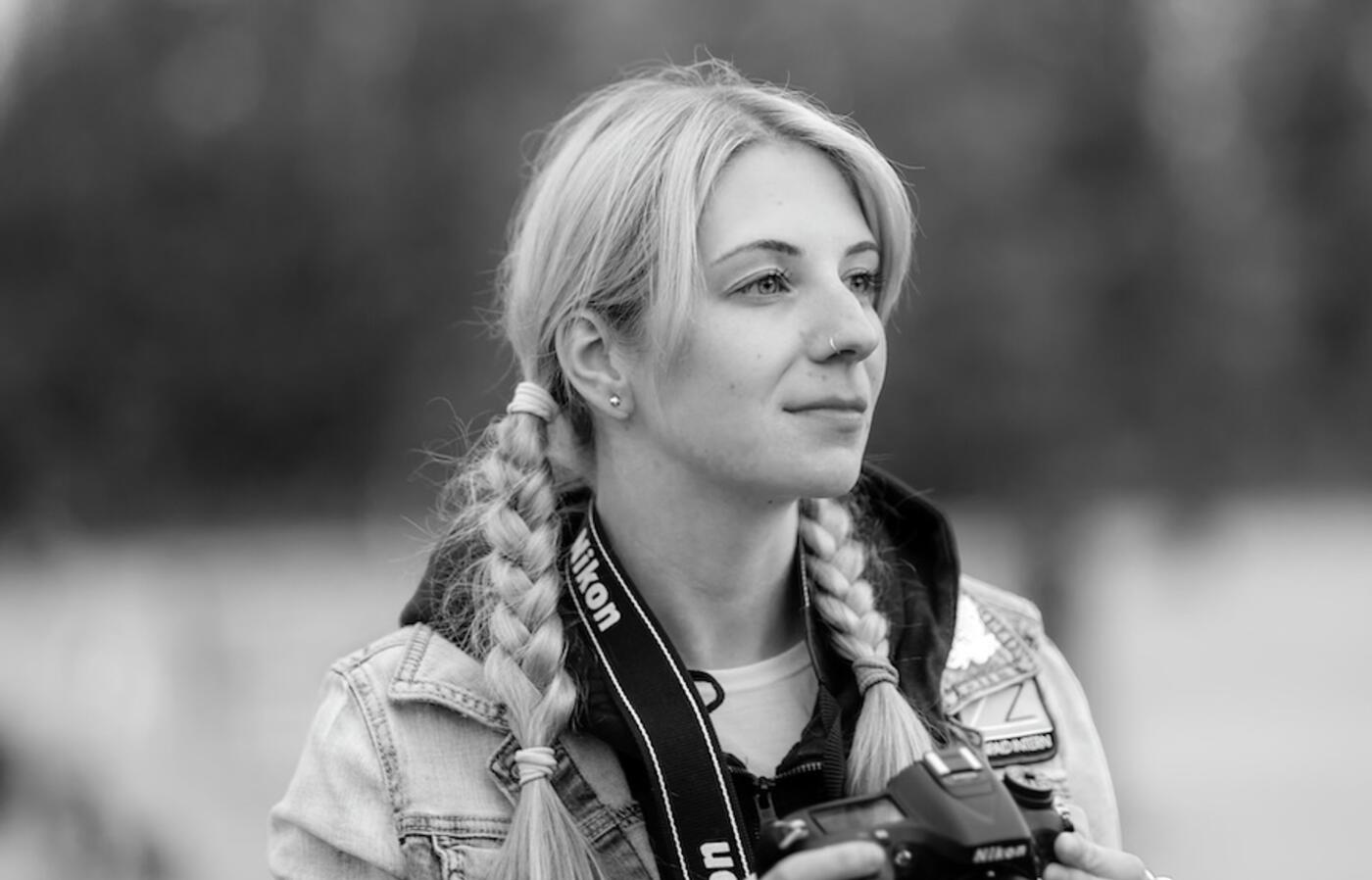 black and white photo of woman holding a camera