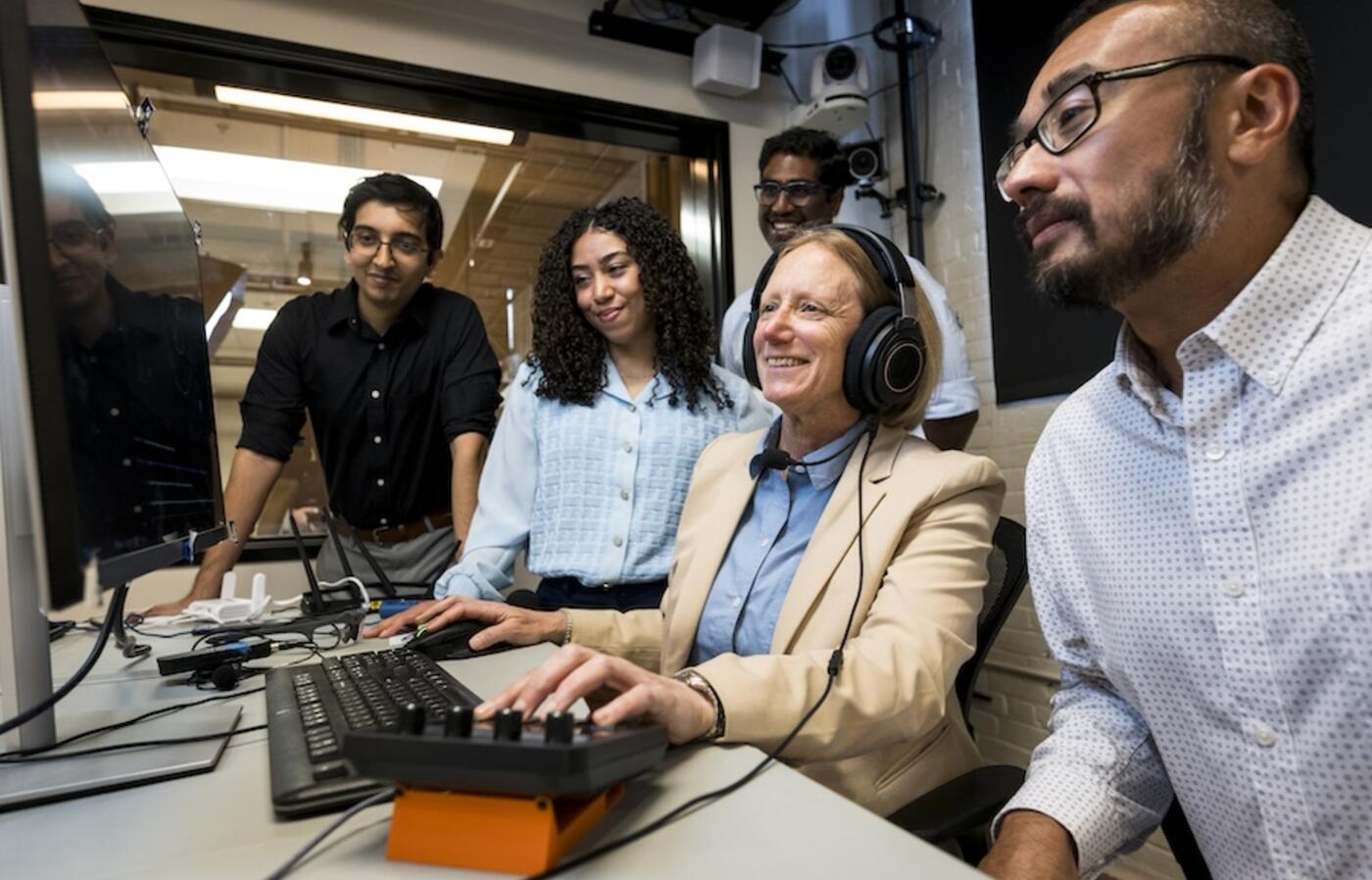 a group of people all looking at a computer screen
