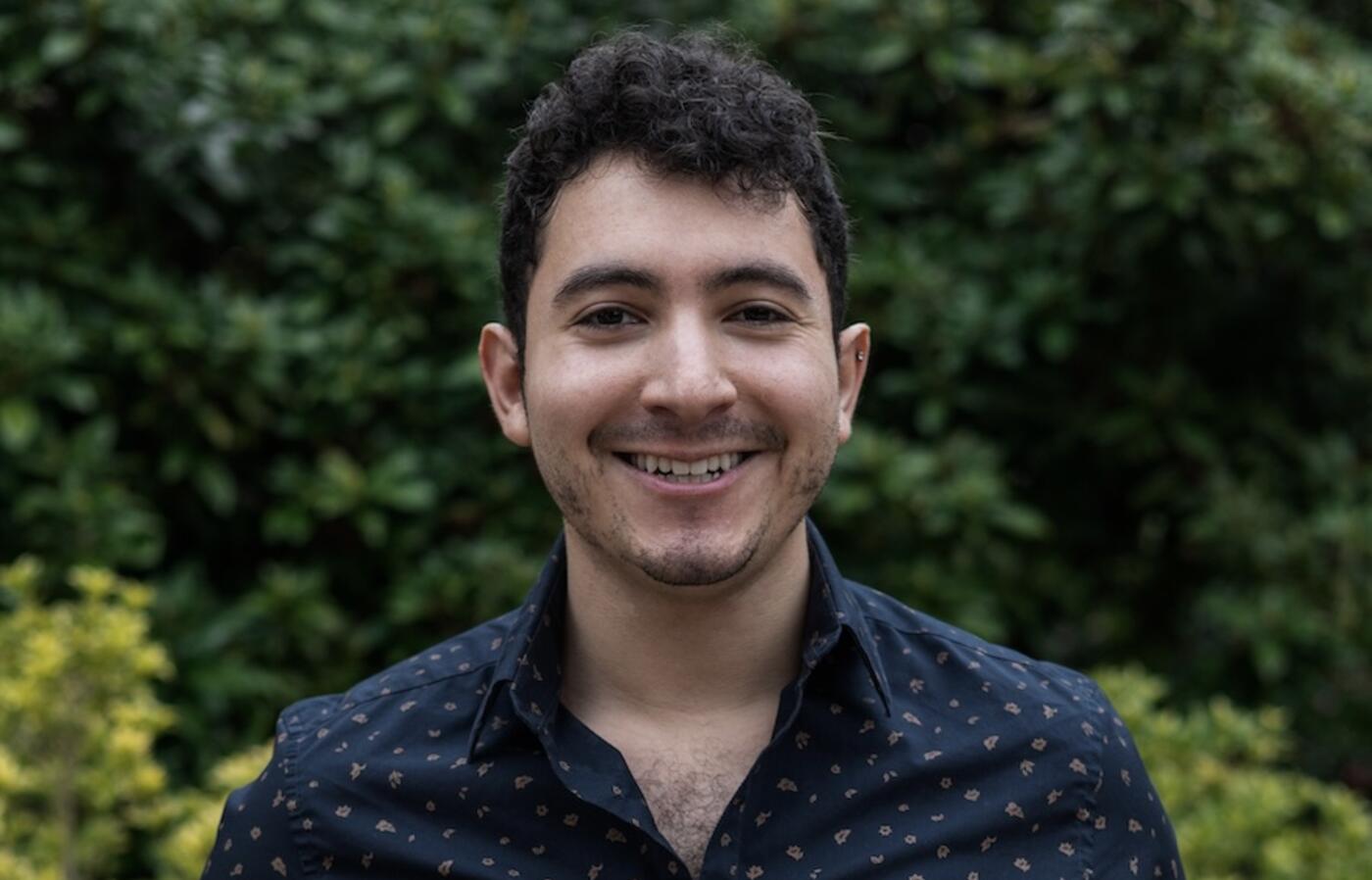 person smiling in front of green background