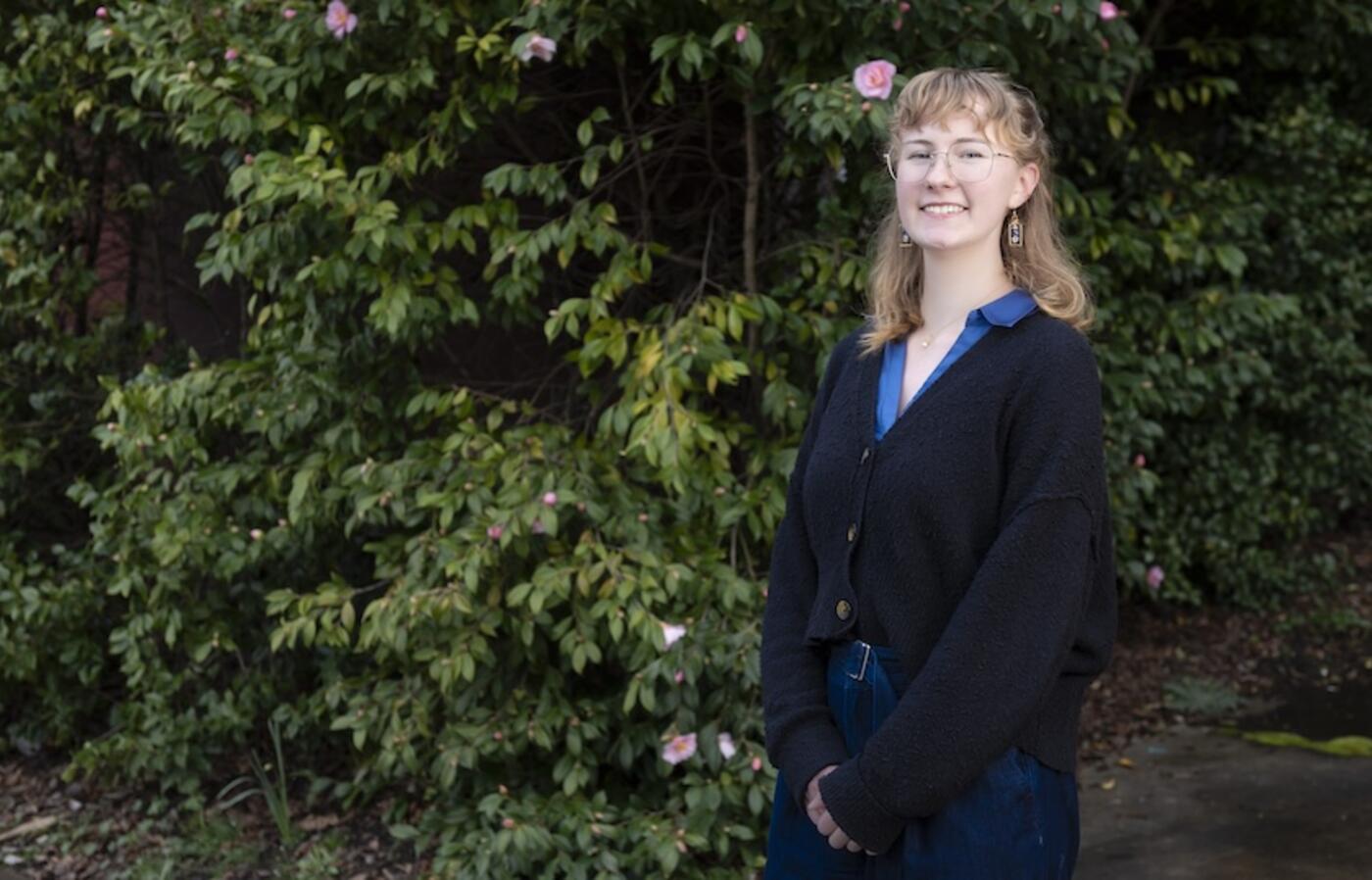 woman standing in front of a flowering bush