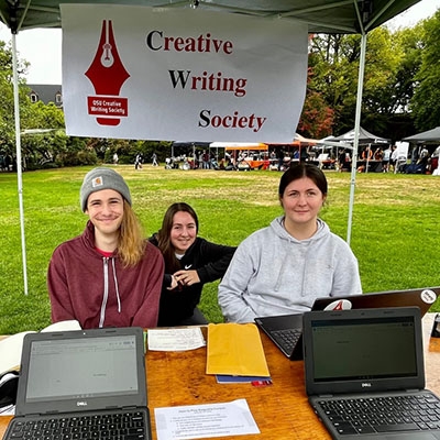 Creative writing society members Ben Toledo, Kat Puglisi, and Sheyanne Loose at a promotional booth