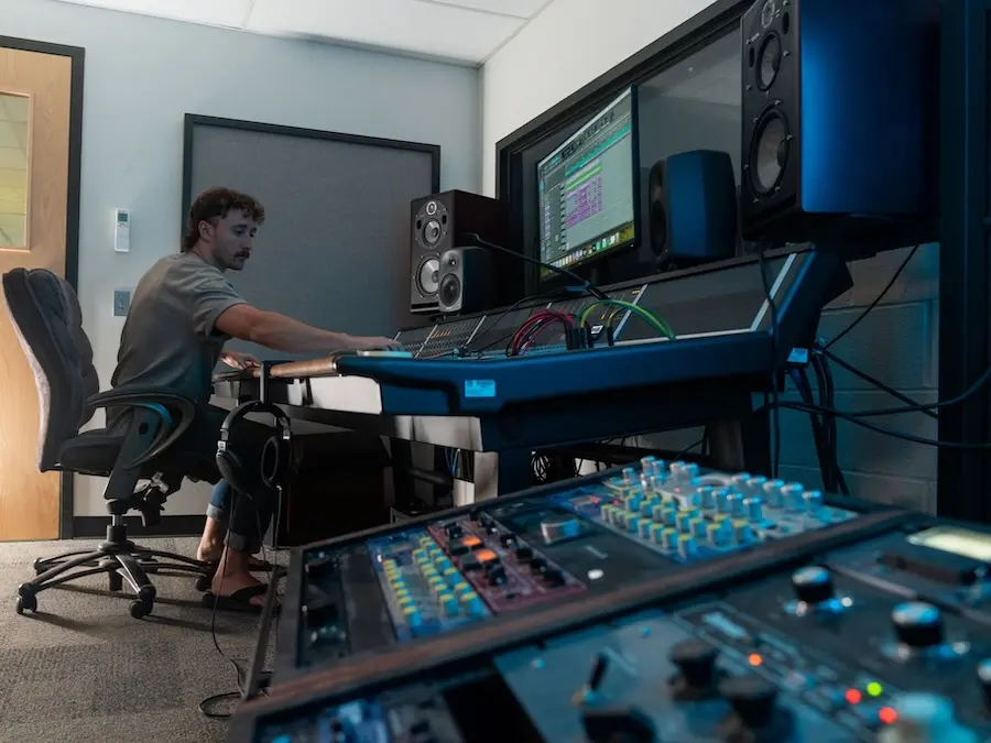 Person using audio mixing board in Snell Hall