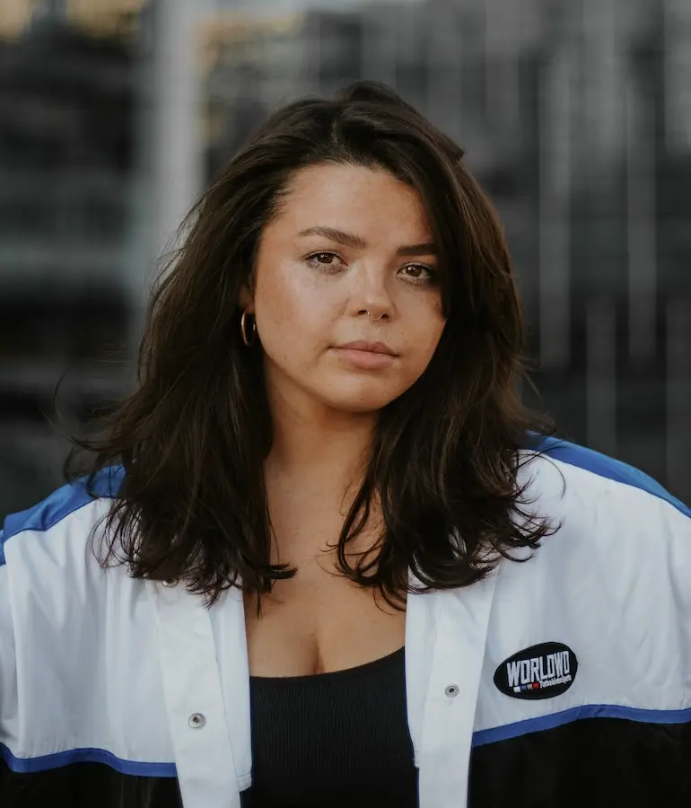 woman in white jacket and black shirt look at the camera