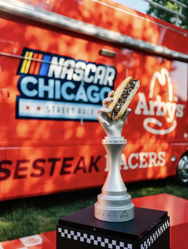 a cheese steak trophy in front of a bus
