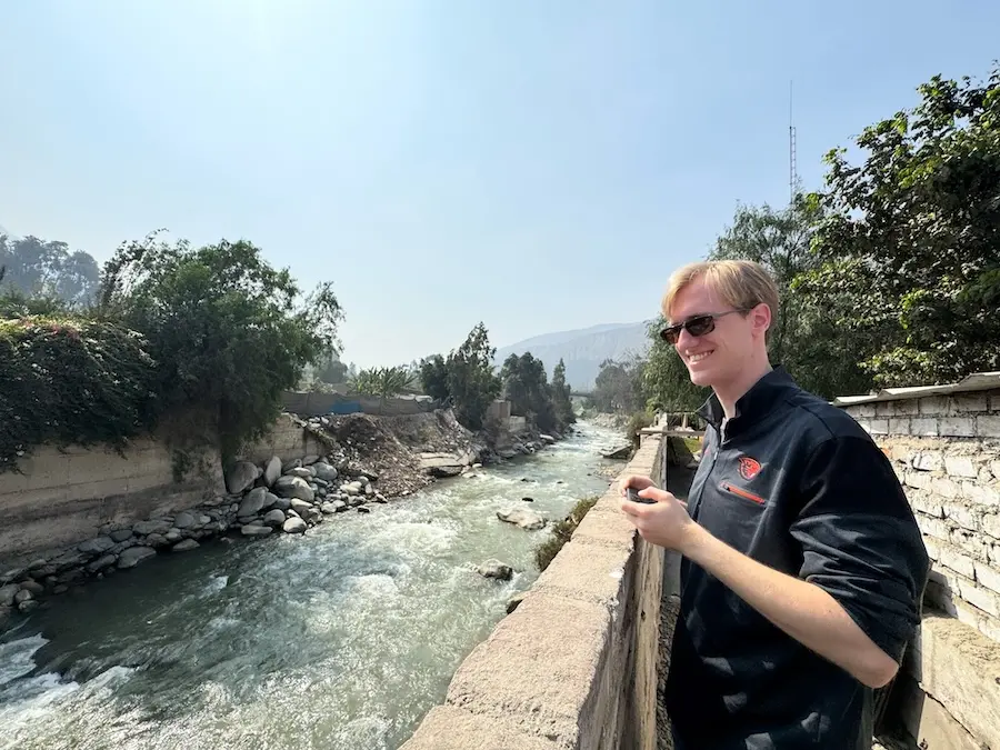 a man standing next to a flowing river