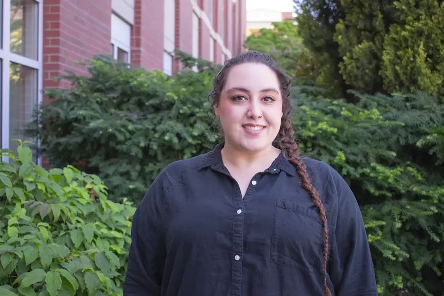 person in black shirt standing in front of a green bush