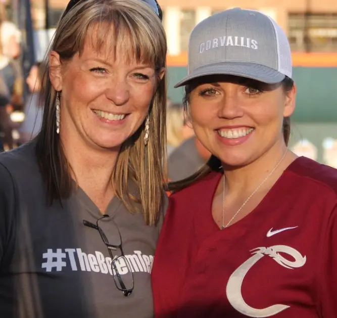 two women standing next to one another smiling at the camera