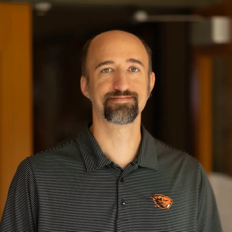 man in black shirt smiling at the camera