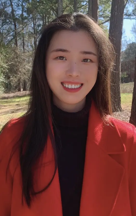 woman in red jacket and black jacket smiling at camera