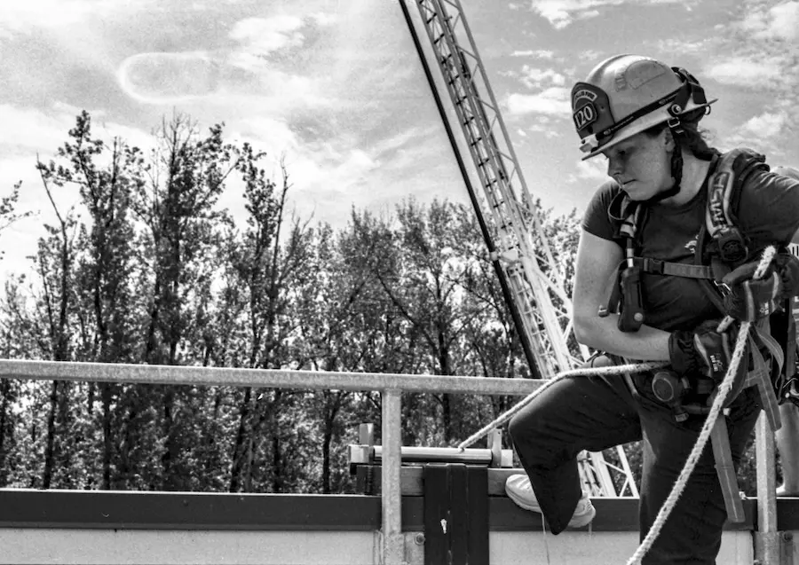 a woman firefighting on top of a building