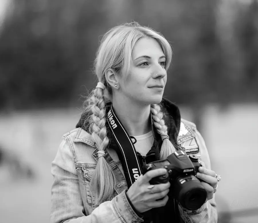 black and white image of a woman holding a camera