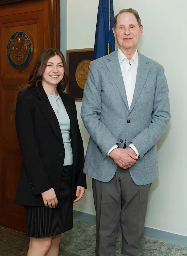 woman and man standing next to one another smiling at the camera