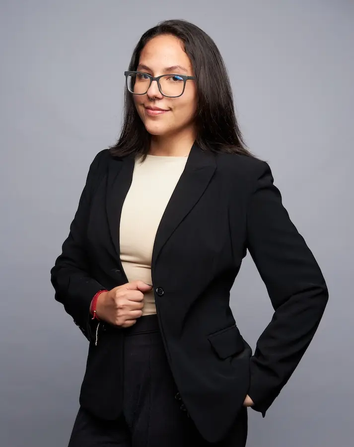 woman wearing black suit standing and smiling at the camera