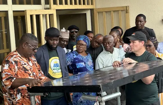 a group of people looking a solar panel