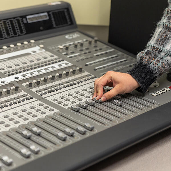 hand moving buttons on a soundboard
