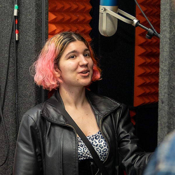 student singing in an audio booth
